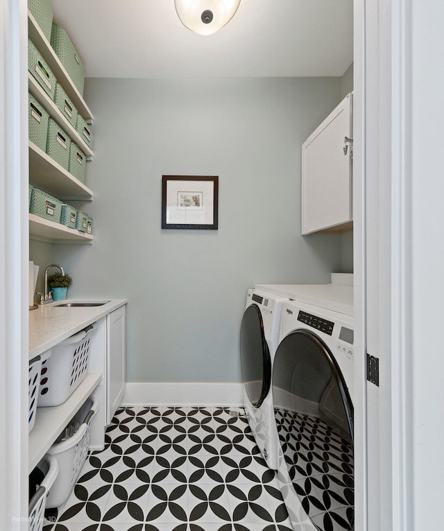 laundry room featuring cabinets, independent washer and dryer, and sink