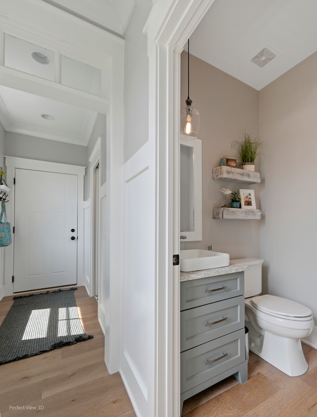 bathroom with vanity, toilet, and hardwood / wood-style floors