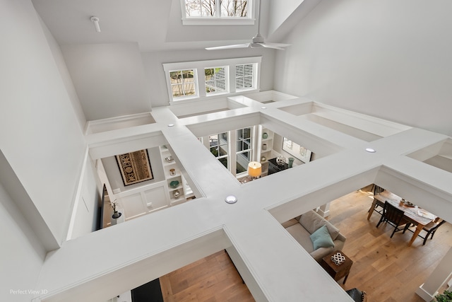 living room featuring hardwood / wood-style flooring, a high ceiling, and ceiling fan