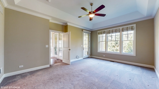 carpeted spare room featuring crown molding, ceiling fan, and a tray ceiling