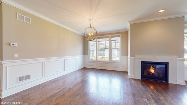 unfurnished living room with dark wood-type flooring, a fireplace, a chandelier, and ornamental molding