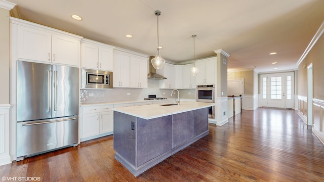 kitchen featuring crown molding, stainless steel appliances, white cabinetry, dark hardwood / wood-style floors, and a center island with sink