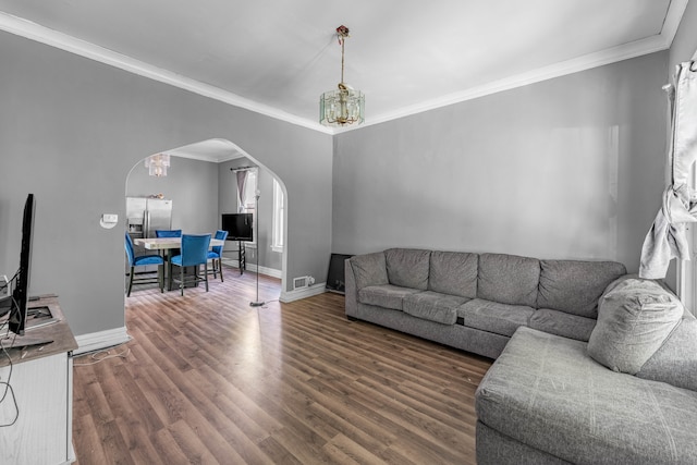 living room with crown molding, an inviting chandelier, and dark hardwood / wood-style flooring