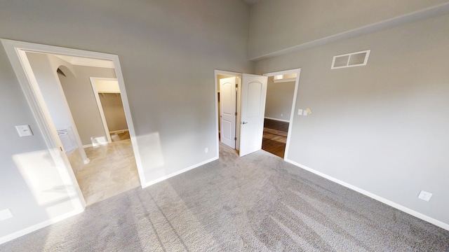 8309 Dylan Dr, Merrillville, IN 46410 - unfurnished bedroom featuring visible vents, carpet floors, baseboards, arched walkways, and a spacious closet