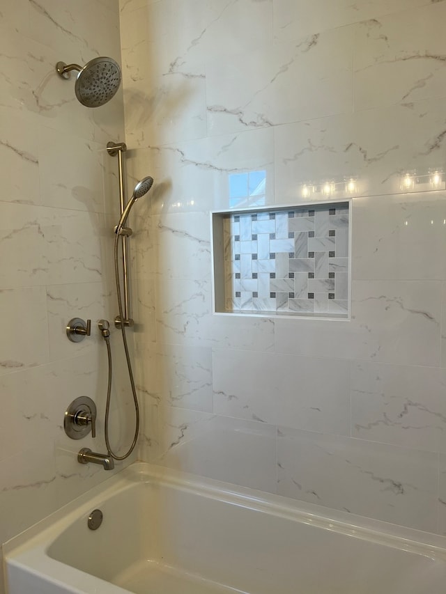 bathroom featuring tiled shower / bath