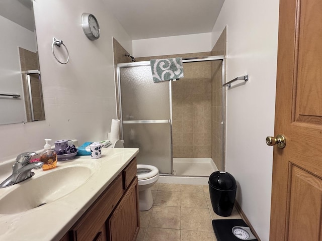 bathroom with toilet, vanity, tile patterned floors, and a shower with door