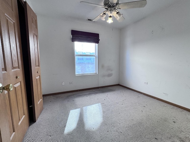 carpeted empty room featuring ceiling fan