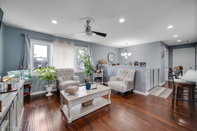 living room featuring ceiling fan with notable chandelier and dark hardwood / wood-style floors