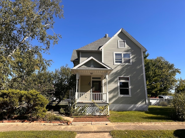 view of front facade with a front yard and covered porch