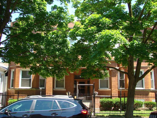 view of front of house featuring brick siding and fence