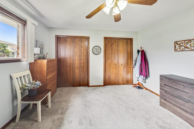 bedroom featuring multiple closets, ceiling fan, and carpet