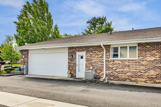 view of front of house with a garage and central AC unit