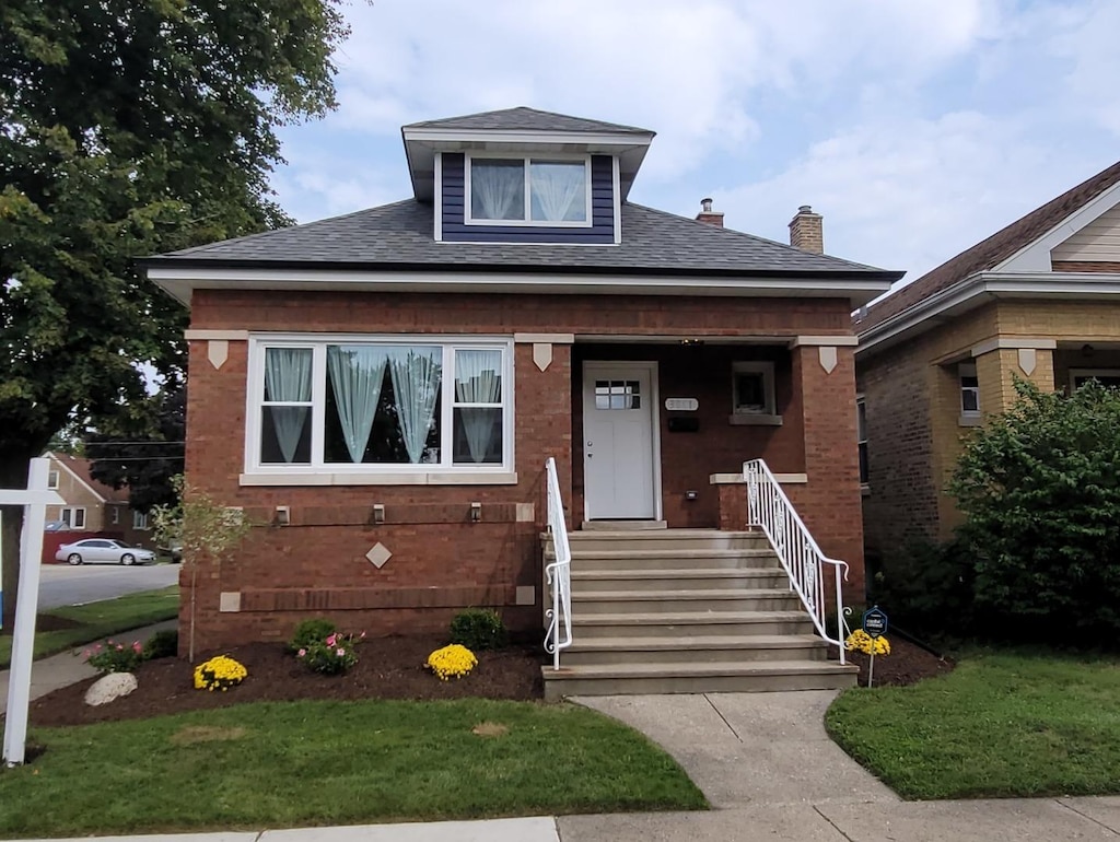 bungalow-style house with a porch and a front lawn