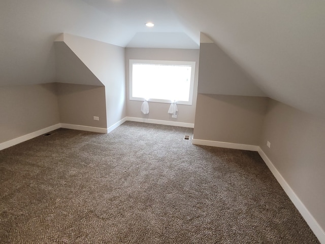 additional living space with vaulted ceiling and carpet floors