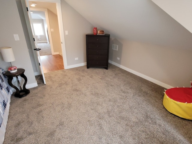 additional living space featuring lofted ceiling and carpet floors