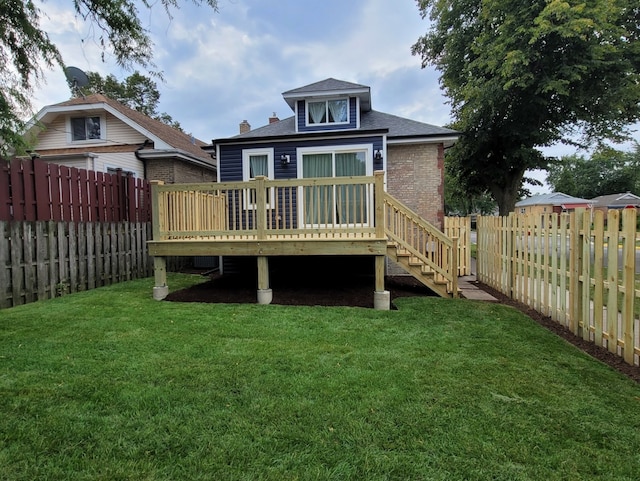 rear view of house featuring a yard and a deck