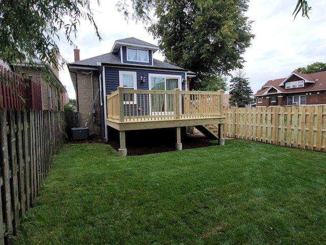 back of property featuring a lawn, a deck, and central AC unit