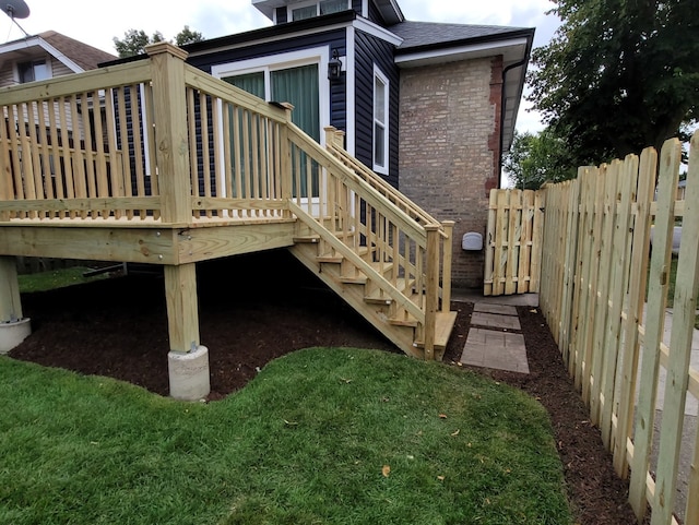 rear view of house with a deck and a lawn