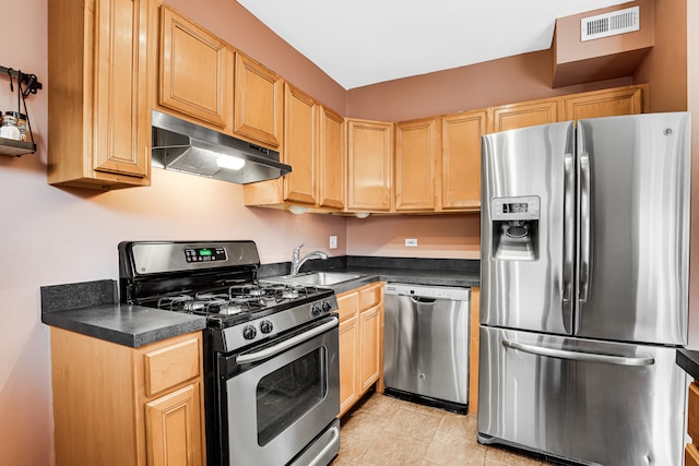 kitchen with light brown cabinetry, stainless steel appliances, and sink