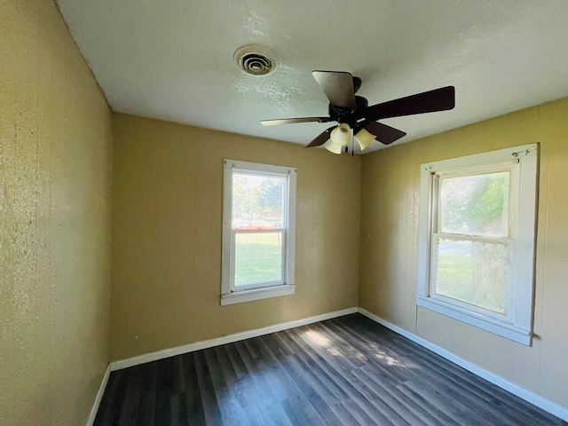 spare room with ceiling fan, dark hardwood / wood-style flooring, and a textured ceiling