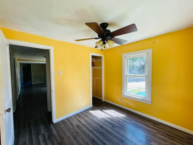 unfurnished bedroom with a closet, ceiling fan, dark hardwood / wood-style floors, and a textured ceiling