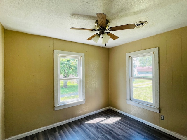 unfurnished room featuring dark hardwood / wood-style flooring, a healthy amount of sunlight, and ceiling fan