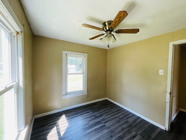 empty room featuring dark wood-type flooring, a textured ceiling, and ceiling fan