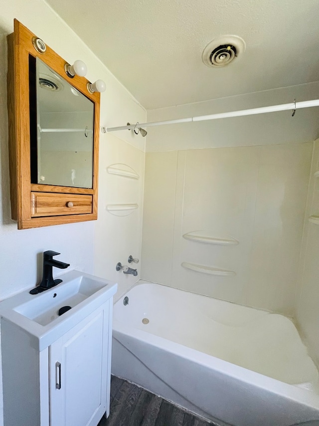 bathroom with vanity, washtub / shower combination, and wood-type flooring