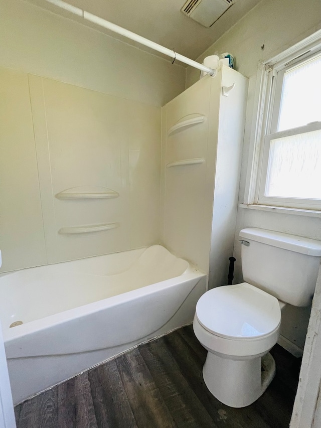 bathroom with toilet, wood-type flooring, and bathing tub / shower combination