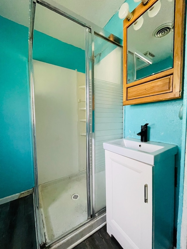 bathroom featuring a shower with door, hardwood / wood-style flooring, and vanity