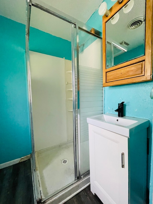 bathroom with vanity, hardwood / wood-style flooring, and an enclosed shower