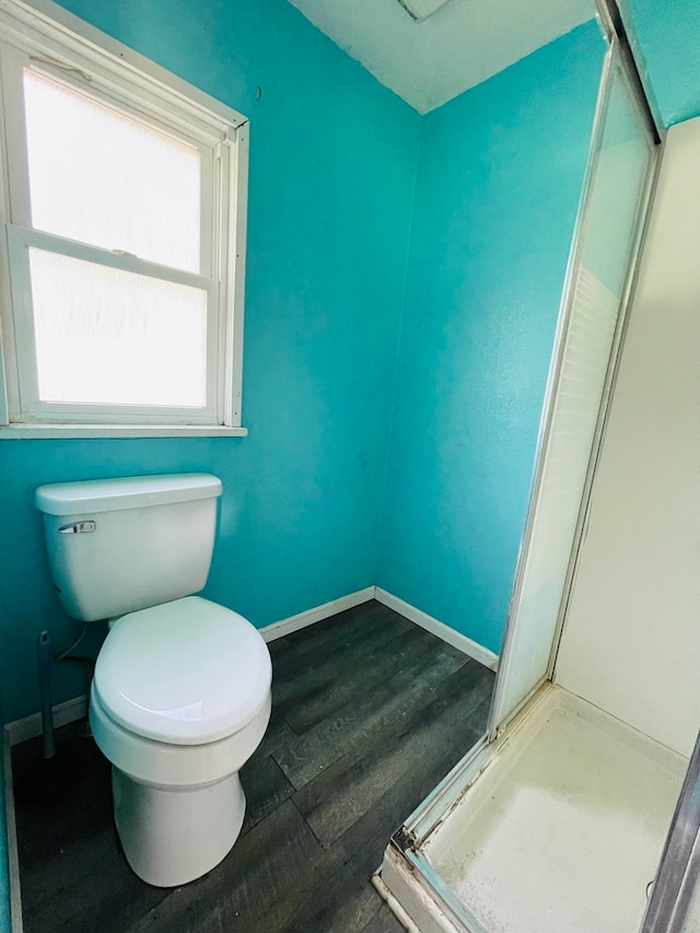 bathroom with wood-type flooring, toilet, and walk in shower