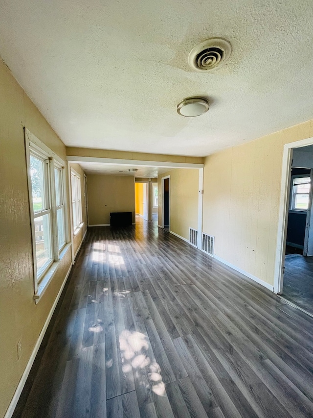 unfurnished living room with dark hardwood / wood-style floors and a textured ceiling