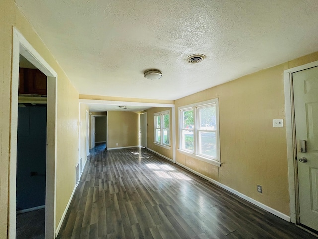 interior space featuring a textured ceiling and dark hardwood / wood-style floors