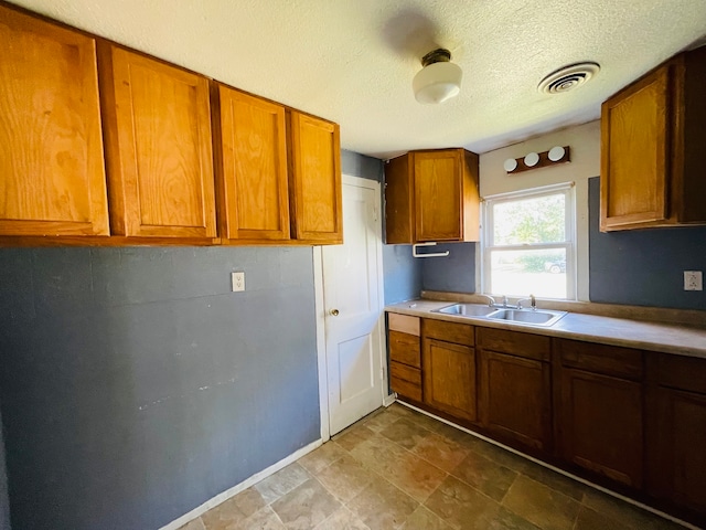 kitchen featuring a textured ceiling and sink