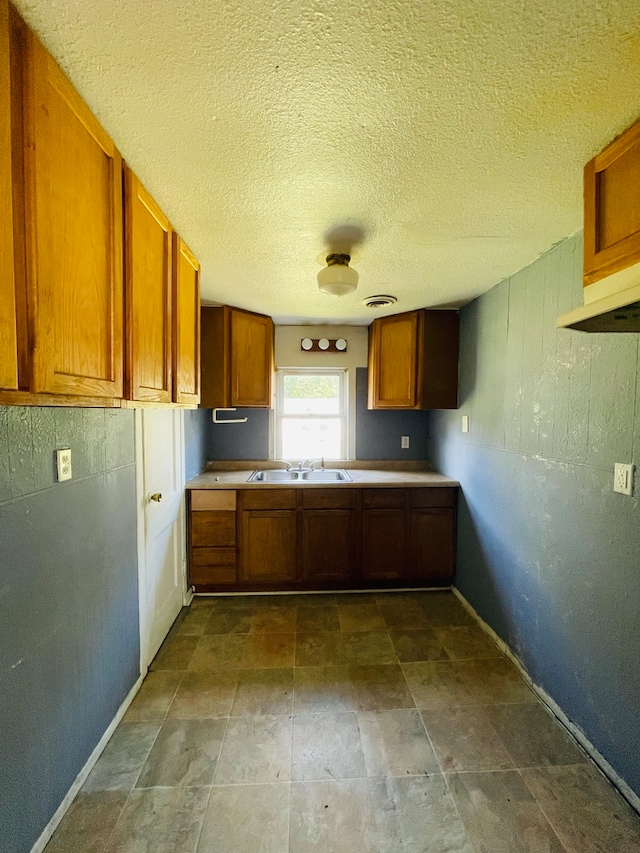 kitchen featuring a textured ceiling and sink