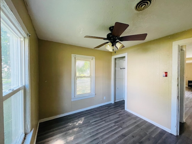 unfurnished room with ceiling fan, dark hardwood / wood-style floors, and a textured ceiling