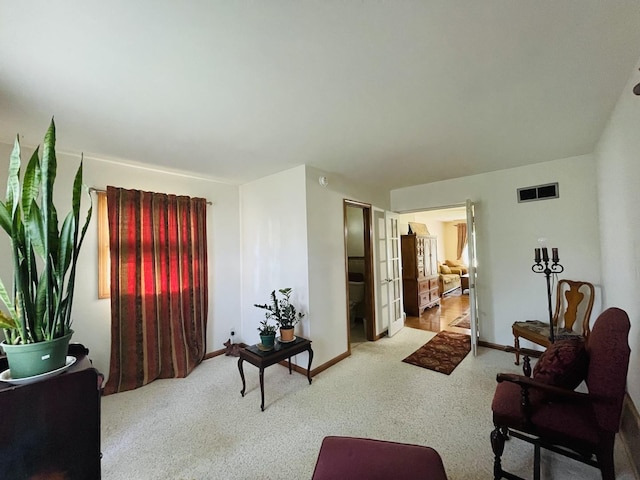 living room with french doors, visible vents, and baseboards