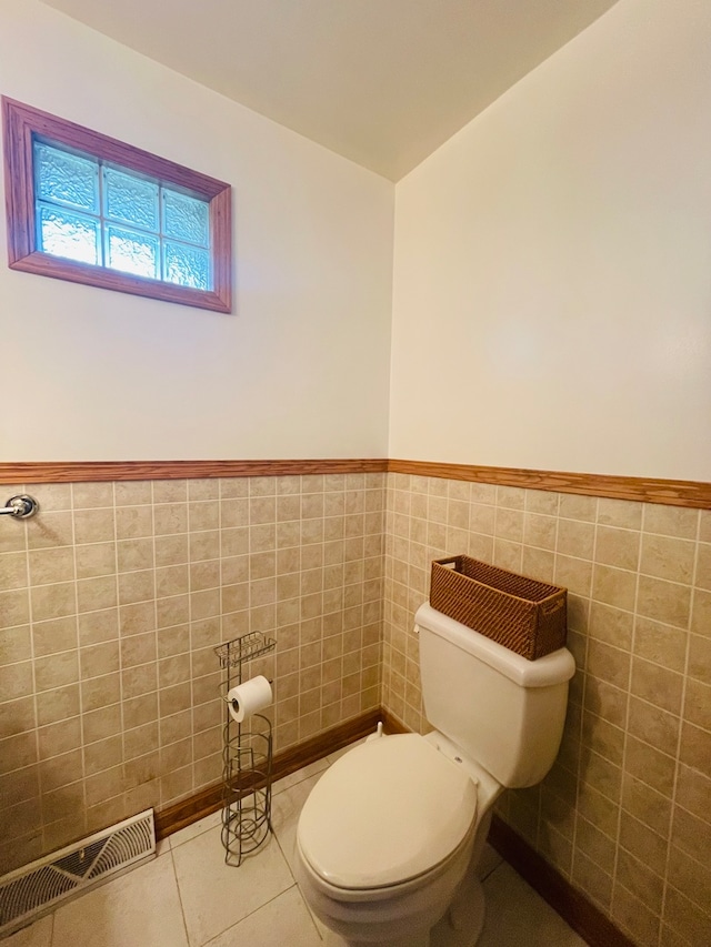 bathroom featuring tile walls, tile patterned flooring, and toilet