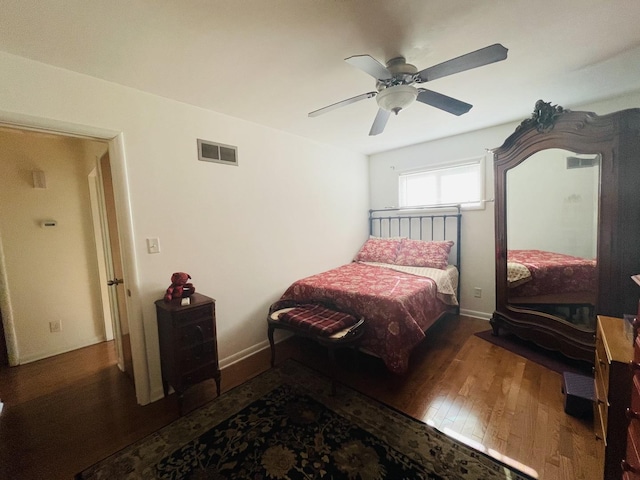 bedroom featuring ceiling fan, wood-type flooring, visible vents, and baseboards