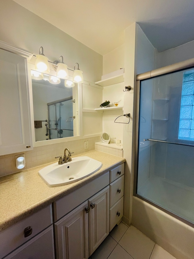 bathroom with shower / bath combination with glass door, vanity, tasteful backsplash, and tile patterned floors