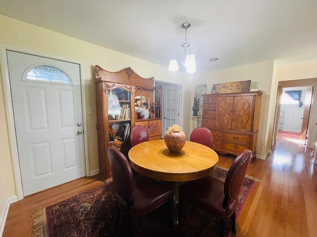 dining room with hardwood / wood-style floors and an inviting chandelier