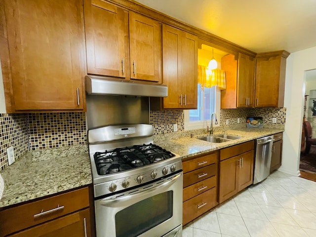 kitchen featuring tasteful backsplash, light stone counters, stainless steel appliances, and sink