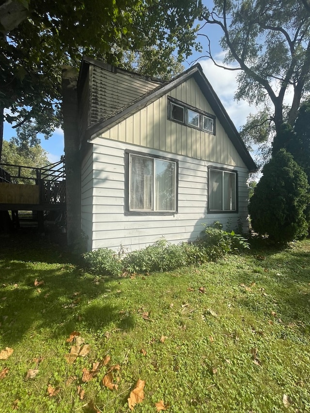 view of property exterior with a yard and a wooden deck