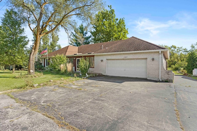 ranch-style house with a front yard and a garage