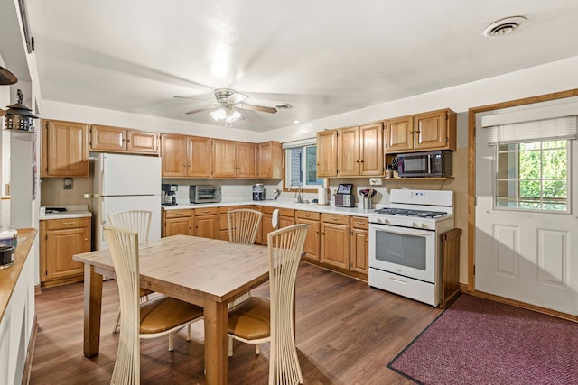 kitchen featuring tasteful backsplash, white appliances, dark hardwood / wood-style flooring, ceiling fan, and sink