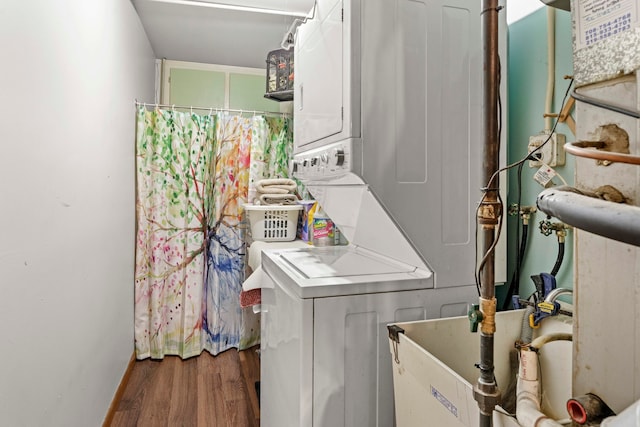 washroom with stacked washer / drying machine and hardwood / wood-style floors