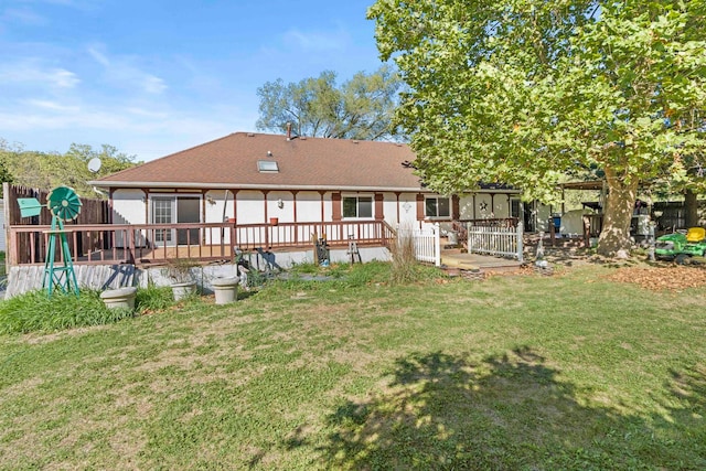 rear view of property with a deck and a lawn