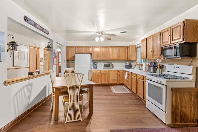 kitchen with ceiling fan, dark hardwood / wood-style floors, and white appliances