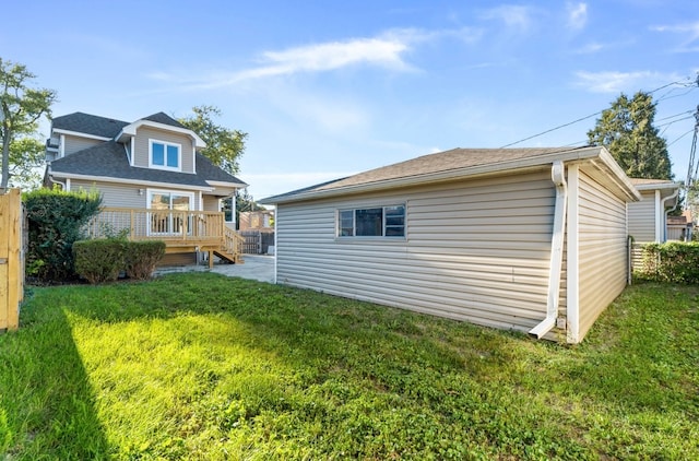 rear view of house featuring a lawn and a wooden deck